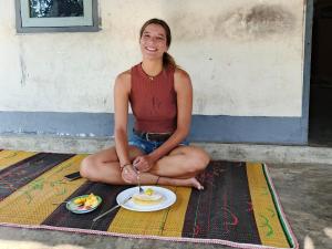 a woman sitting on the floor with a plate of food at Sendikala Lombok in Pancor