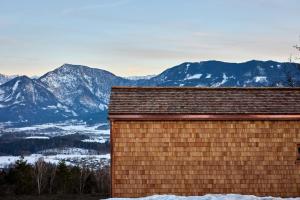 un edificio con montagne innevate sullo sfondo di Rosenholz Ferienhäuser a Köttmannsdorf