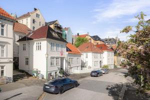 eine Stadtstraße mit vor Gebäuden geparkten Autos in der Unterkunft Nordnes Apartment in Bergen + 3 Fotos