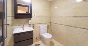 a bathroom with a toilet and a sink and a mirror at Deluxe Ocean Apartment Heliopolis in Cairo +23 photos