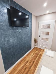 un soggiorno con una TV a parete di MDM APARTMENT CITY CENTER FELICITA DeLUXE a Ruse