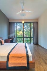 a bedroom with a large bed with a large window at Golden Sands Residence - Unawatuna - 1 and 2 bedrooms apartments in Unawatuna