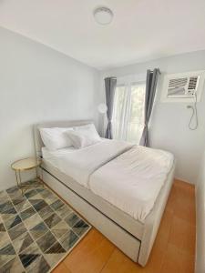 a bedroom with a bed with a window and a rug at MQ Staycation at One Oasis in Cagayan de Oro +41 photos