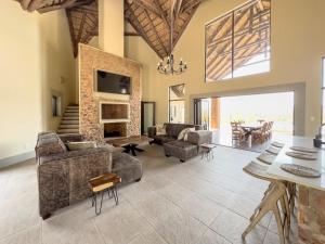 a large living room with couches and a fireplace at Tebuah Private Lodge, Mabalingwe in Mabula