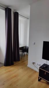 ein Wohnzimmer mit Vorhang und Tisch in der Unterkunft Casa ao centro - Apartamento Angrego in Angra do Heroísmo