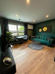 a living room with a green couch and a table at Modernes Apartment Bremerhaven in Bremerhaven +4 photos