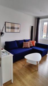 ein Wohnzimmer mit einem blauen Sofa und einem Tisch in der Unterkunft Casa ao centro - Apartamento Angrego in Angra do Heroísmo + 2 Fotos