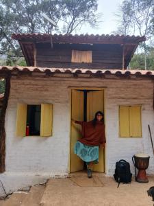 een vrouw die in een deur van een huis staat bij Canto da Águia in Ouro Preto