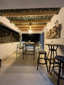 a room with tables and chairs and a wall with paintings at Le Voyageur By the Sea - Furnished Rooms in Larnaka