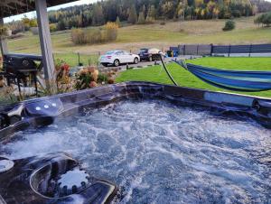 a hot tub in a backyard with a hammock at Jastrzębie Gniazdko in Jastrzębik
