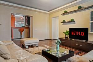 Una sala de estar con un sofá y un televisor. en 4 Rooms Unirii 47, en Bucarest