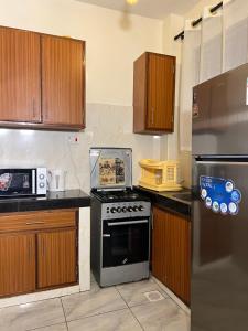 a kitchen with a stove and a refrigerator at beautifully furnished one bedroom apartment in vok off nyali road in Mombasa