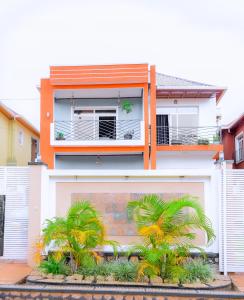 una casa blanca con palmeras delante en Prime Luxury Apartments, en Kigali