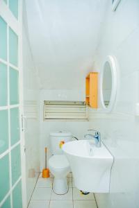 Un baño blanco con inodoro y lavabo. en Prime Luxury Apartments, en Kigali 15 fotos más