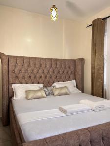 a large bed with a large headboard in a bedroom at beautifully furnished one bedroom apartment in vok off nyali road in Mombasa