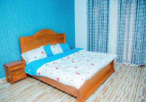 Un dormitorio con una cama con paredes azules. en Prime Luxury Apartments, en Kigali