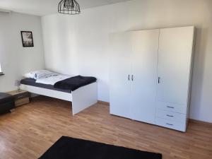 a bedroom with a bed and a white cabinet at Große Komfortable Monteurswohnung in Gutenacker +3 photos