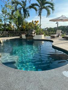 a swimming pool with a fountain and palm trees at Casa Cerritos in Sayulita