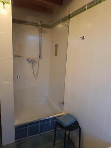 a bathroom with a tub and a stool in it at FEWO Villa Farbenfroh Monteurzimmer Garten Wlan 3SZ 120qm in Wathlingen +19 photos
