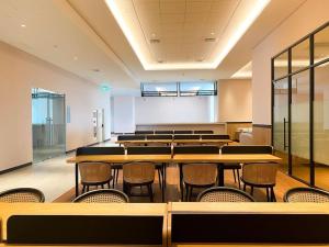 an empty classroom with tables and chairs in it at Menara Jakarta Condo JI Expo PRJ by Blezz in Jakarta +30 photos