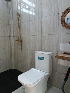 a bathroom with a white toilet and a sink at Rumah Kodel2 in Bukit Lawang +17 photos