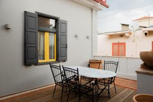 a patio with a table and chairs and a window at Archo Nafplio Suites & Rooms in Nafplio