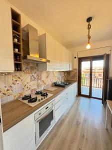 a kitchen with white appliances and a wooden floor at La Casa di Enea in Rome
