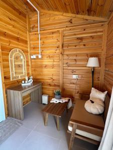 a bathroom with a sink and a bench in a cabin at Wadi Bani Khalid - Al Joud Green Hostel 2 in Dawwah