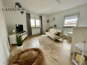 a living room with a couch and a tv at FeWo Büdingen - Landhaus in Büdingen