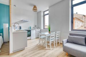 a kitchen and living room with a table and chairs at Le Cocon à Muret in Muret