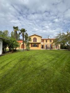 a large yard with a house and palm trees at La Villa des Moments Chaleureux in Pompignac