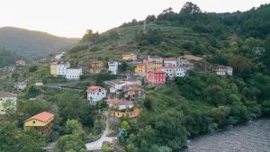 a group of houses on a hill next to a river at Apartamentos Bágoas de Mencía Peares Ribeira Sacra in Carballedo