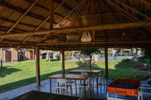 twee tafels en stoelen onder een paviljoen in een park bij Altos de Brochero Cabañas & Padel in Villa Cura Brochero