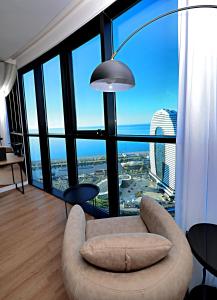 a living room with a couch and a large window at Sea View Plaza Batumi Centre in Batumi