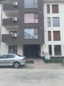 a silver car parked in front of a building at Charlye Apartament in Craiova