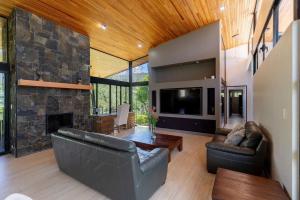 una sala de estar con sofás y una gran chimenea de piedra. en Casa Turrialba, en Turrialba