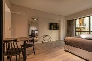 a bedroom with a bed and a table and a mirror at Up Viamonte Hotel in Buenos Aires