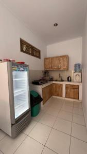 a kitchen with wooden cabinets and a refrigerator at D'carik Surf & Stay in Canggu