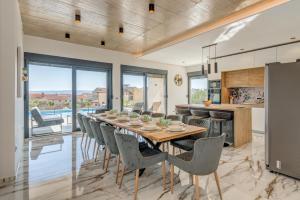 eine Küche und ein Esszimmer mit einem langen Tisch und Stühlen in der Unterkunft Luxury Villa Providenza in Kaštela