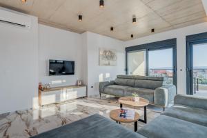 ein Wohnzimmer mit zwei Sofas und einem Fernseher in der Unterkunft Luxury Villa Providenza in Kaštela