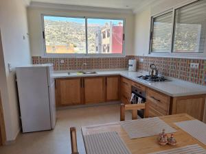 a kitchen with a refrigerator and a table in it at House Timenziwin Tamraght in Tamraght Ouzdar