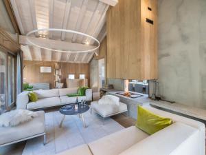 Una sala de estar con muebles blancos y chimenea. en Chalet de luxe avec jacuzzi, hammam et salle de cinéma à Courchevel - FR-1-562-43, en Courchevel