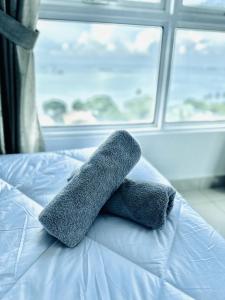 two towels on a bed in front of a window at 10pax 3-Bedroom l Seaview l Georgetown l Gleneagles l Mansion One in George Town