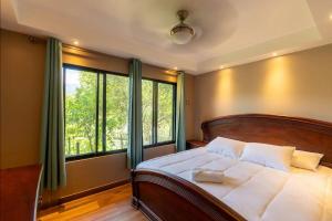 Un dormitorio con una cama con una ventana grande. en Casa Turrialba, en Turrialba 22 fotos más