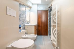 a bathroom with a toilet and a sink at San Luigi Apartment in Beinasco +17 photos