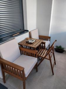 drie stoelen en een houten tafel en een tafel en stoelen bij Jagodina apartman MM in Jagodina +13 foto's