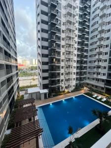 a swimming pool in the middle of two tall buildings at Iloilo Condo Sm City Style Residences in Iloilo City