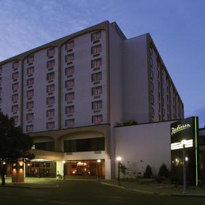 um grande edifício de hotel com uma placa em frente em Radisson Hotel Bismarck em Bismarck