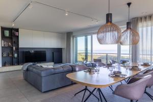 a living room with a table and a couch at The Bay luxurious full sea view in Cadzand