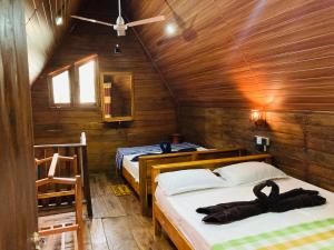 una camera con due letti in una baita di legno di Sigiri Lodge Tree House a Sigiriya